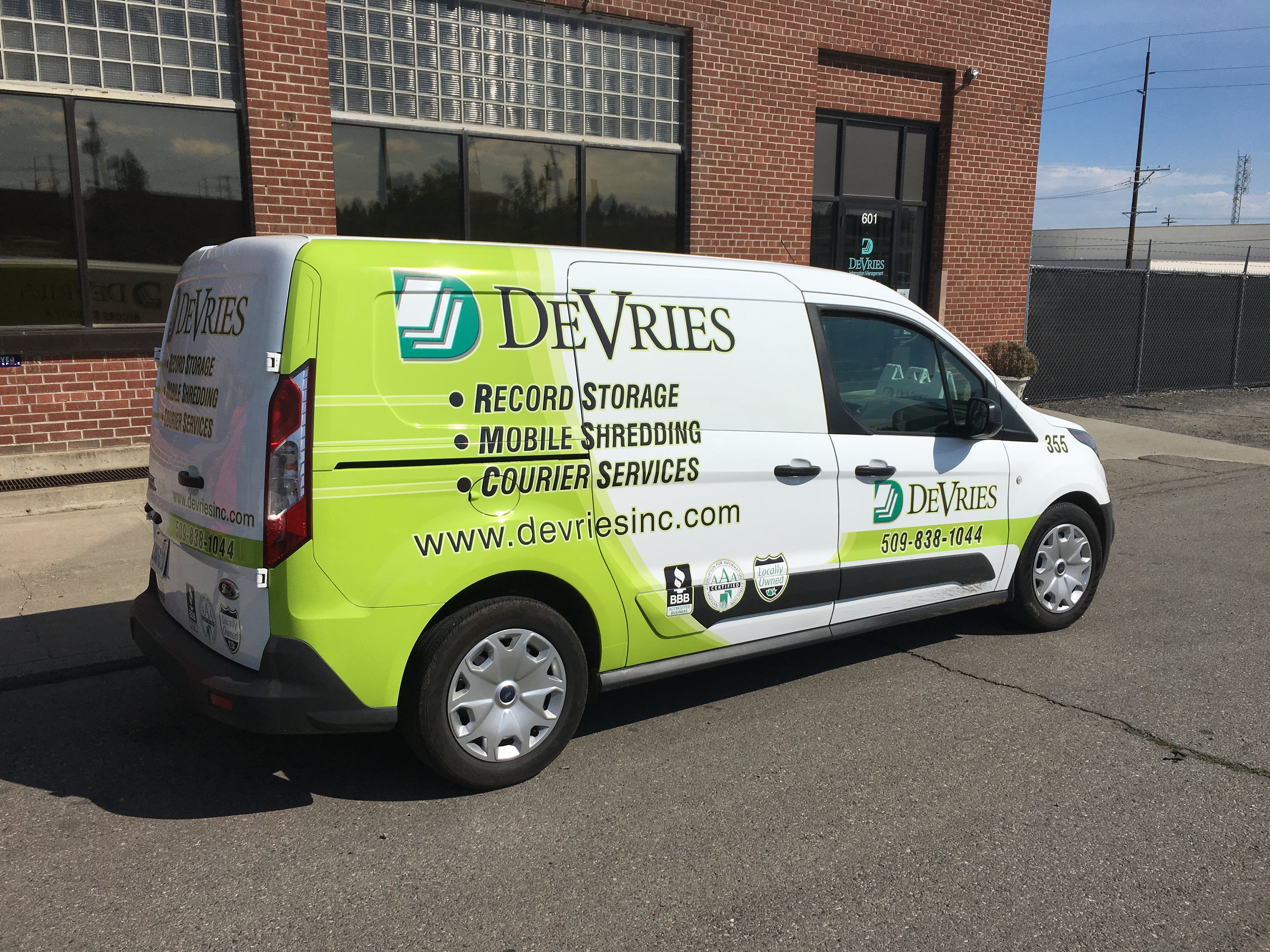 DeVries van in front of the DeVries brick building