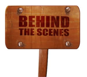 behind the scenes text on wooden sign