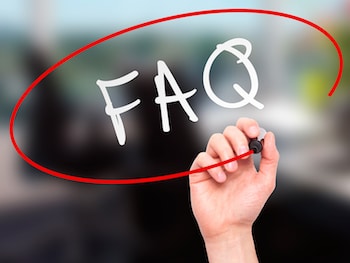 Man Hand writing FAQ - Frequently Asked Questions with marker on transparent wipe board. Business, internet, technology concept.