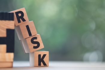 Risk assessment, decision to accept business result in uncertainty, unpredictable situation concept, cube wooden block with alphabet building the word RISK.