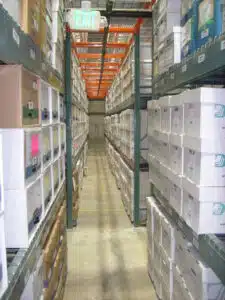 View looking down an aisle of DeVries records center with many boxes stacked on warehouse shelves