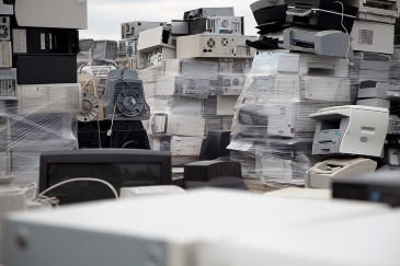 Many computers and printers stacked and ready to be recycled