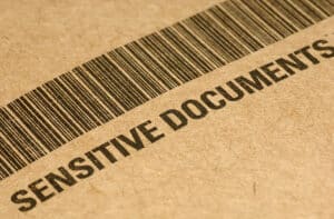 Close-up of file folder with barcode and the words, "Sensitive Documents"