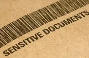 Close-up of file folder with barcode and the words, "Sensitive Documents"