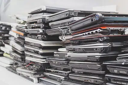 Many computers and printers stacked and ready to be recycled
