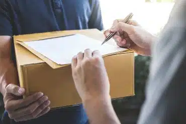 Delivery mail man giving parcel box to recipient and signature form, Young owner signing receipt of delivery package from post shipment courier, Home delivery service and working with service mind.