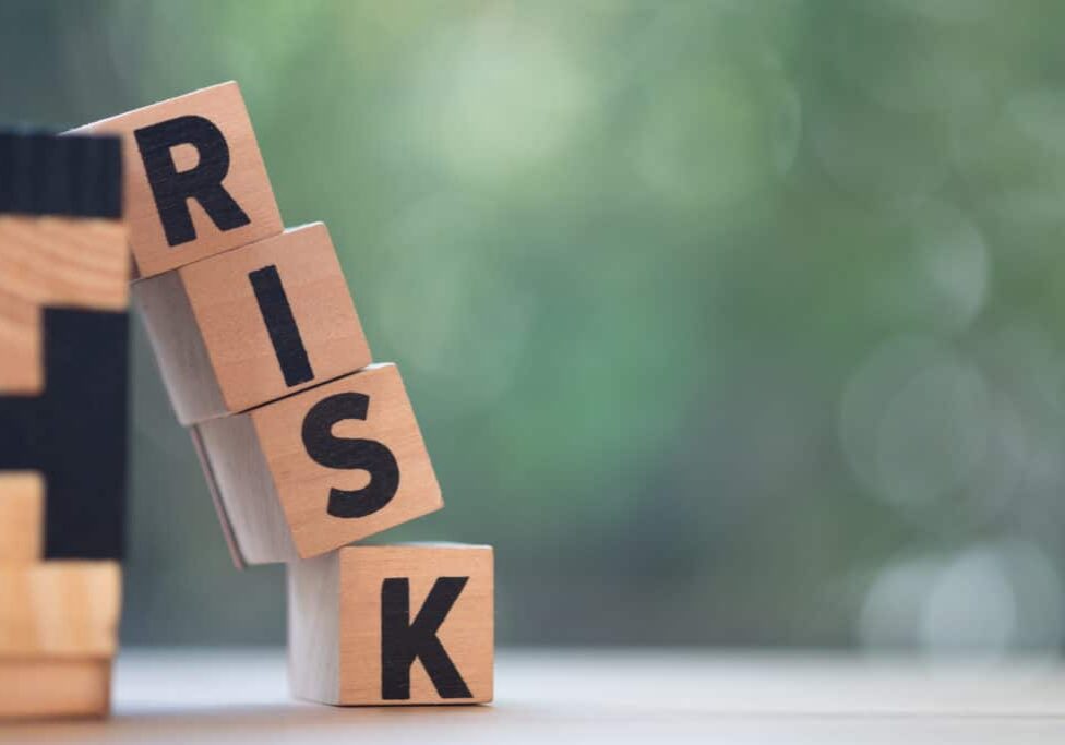 Risk assessment, decision to accept business result in uncertainty, unpredictable situation concept, cube wooden block with alphabet building the word RISK.