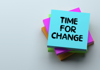 A stack of sticky notes. The top note reads "Time for Change"