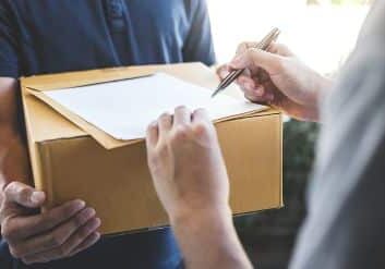 Delivery mail man giving parcel box to recipient and signature form, Young owner signing receipt of delivery package from post shipment courier, Home delivery service and working with service mind.